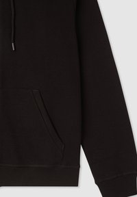 Czarny rękaw bluzy oraz kieszeń kangurka z ribbowanym mankietem i dołem, z detalami sznurka, na jasnoszarym tle.