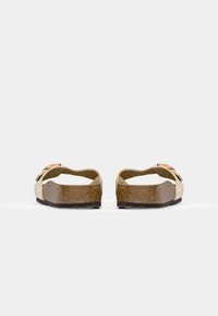 Beige sandaler med kork såle, åpen bakdesign og en dekorativ rem med kobberdetalj. Teksturerte gummisåler.