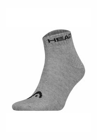 Calzini alla caviglia grigi realizzati in un materiale a maglia liscia. Presentano il logo nero "HEAD" sulla parte superiore e un motivo curvo vicino alla punta.