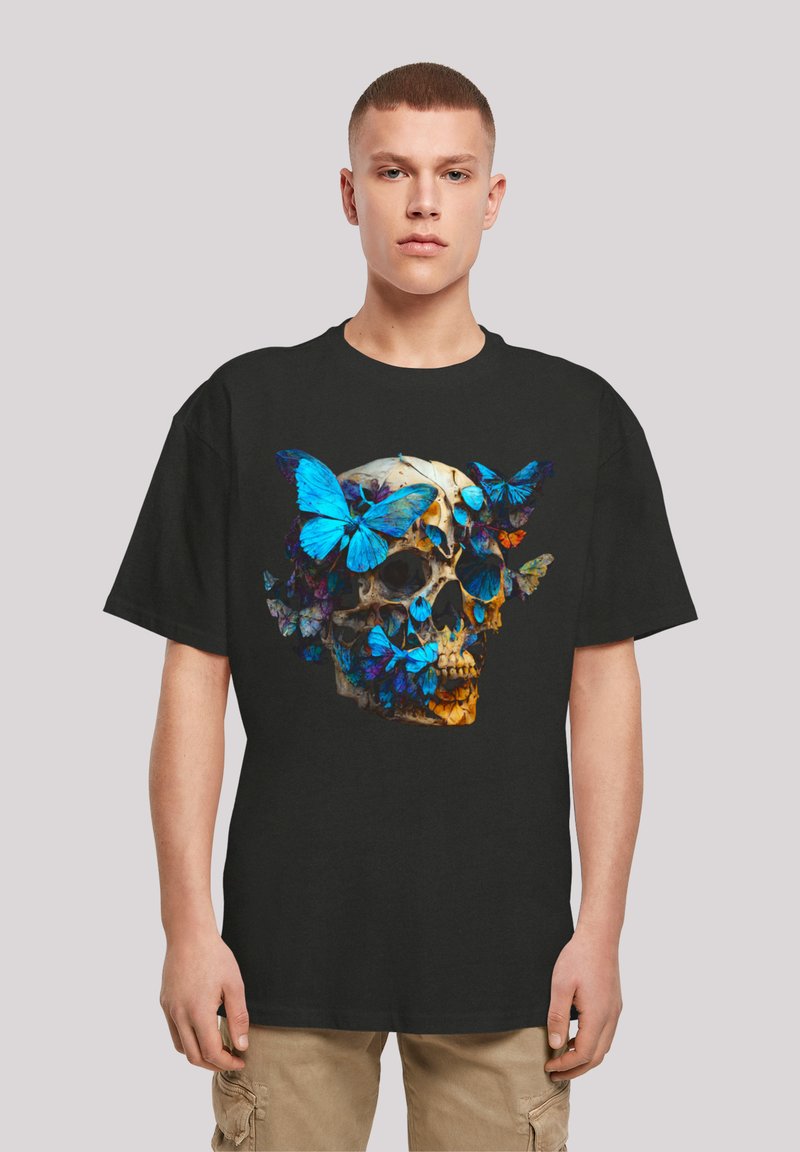 Black t-shirt featuring a design of a skull surrounded by vibrant blue butterflies, showcasing detailed textures and colors.