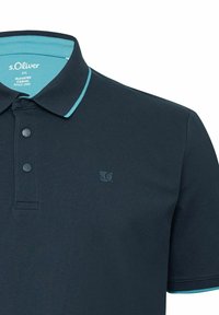 Marineblaues Poloshirt mit türkisfarbenem Akzent am Kragen. Verfügt über zwei Knöpfe und ein kleines Logo auf der Brust. Hergestellt aus strukturiertem Stoff.