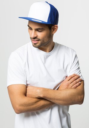 Bijela i plava trucker kapa s zakrivljenim vizirjem, mrežastim stražnjim dijelom i čvrstim prednjim panelom. Nosila se uz običnu bijelu majicu.