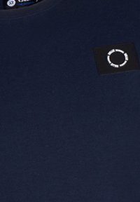 Navyblaue Baumwoll-T-Shirt mit Rundhalsausschnitt und einem quadratischen schwarzen Patch, der in der oberen linken Ecke eine weiße kreisförmige Grafik zeigt.