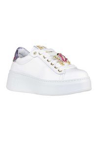 Sneaker bianca in pelle con suola platform, adornata con un pezzo decorativo rosa e oro, e occhielli dorati per i lacci.