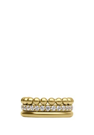 Three stacked gold rings: one with smooth surface, one with round beads, and one with embedded clear gemstones.