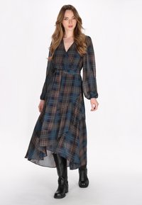 Maxi jurk in een blauw geruit patroon met lange mouwen en een wikkelontwerp, met een vloeiende zoom en een geknoopte taille-detail.