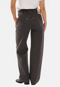 Dark gray wide-leg jeans with a high waist, featuring classic back pockets and a leather logo patch on the waistband.