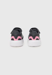 Zapatillas deportivas negras con detalles en rosa, que cuentan con una parte superior de malla transpirable, cuello acolchado y una suela de goma blanca. Elementos de diseño minimalistas.