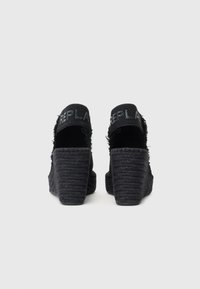 Černé wedge sandály s texturovaným svrškem z látky, s podpatky pletenými z provazu a značkou "REPLAY" na zadním popruhu. Mají design se zavřenou patou.