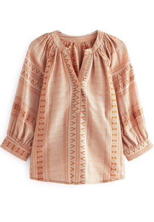 Beige blouse met lange mouwen, oranje geometrische patronen, een geplooide halslijn en elastische manchetten op een witte achtergrond.