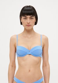 Lyseblå push-up bikini topp med justerbare tynne stropper, underwire støtte og en jevn, glansfull tekstur. Ingen mønstre eller utsmykninger.