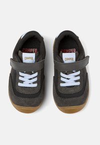 Zapatillas de ante y tejido gris con cordones blancos, correa de velcro y suela de goma. Logotipo "Camper" en la lengüeta y en la plantilla.