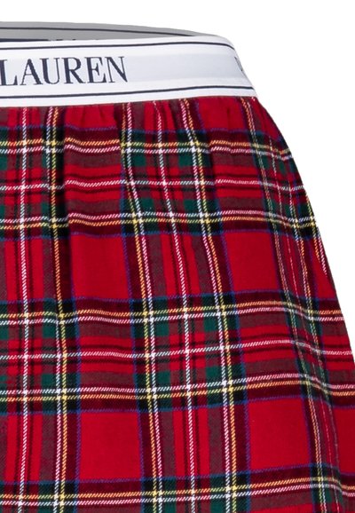Punaiset ruudulliset bokserit, joissa valkoinen joustava vyötärönauha ja "LAUREN"-logo. Kuosissa on vihreitä ja keltaisia yksityiskohtia punaisella taustalla.
