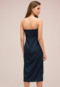 Strapless Jeanskleid in Dunkelblau, figurbetonter Schnitt, knielang, glatte Textur mit subtilem Glanz, mit geradem Rücken und ohne Verzierungen.
