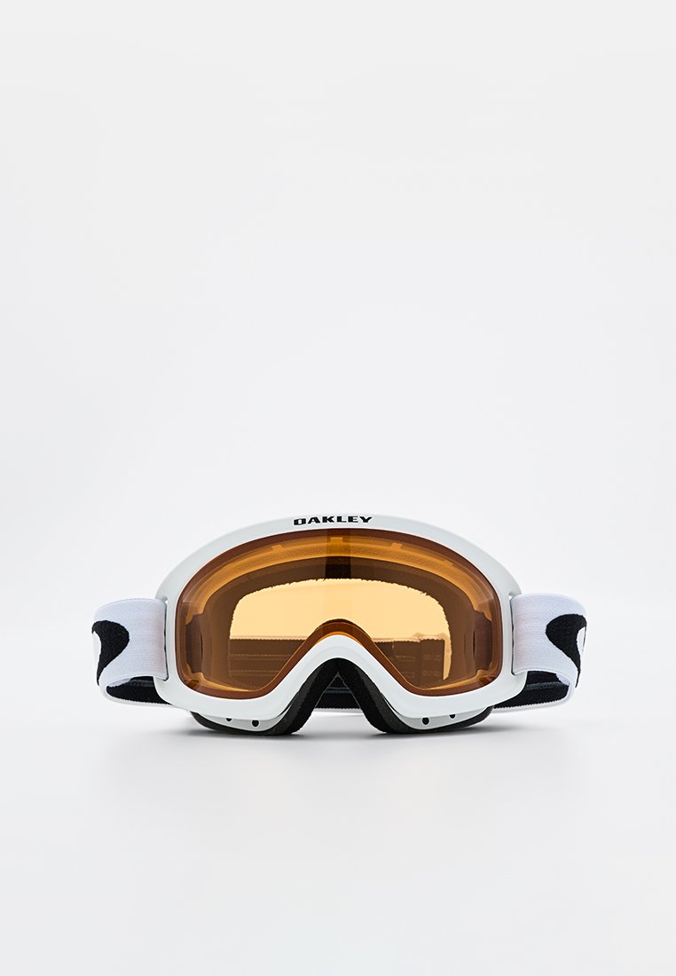 Gafas de esquí Oakley blancas con lentes de tono naranja y correa ajustable en blanco y negro sobre un fondo blanco.