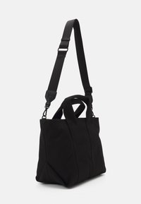 Borsa a spalla in tessuto nero con una forma strutturata, manici superiori e una tracolla regolabile. Presenta linee eleganti e una texture opaca.