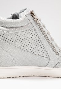 Lys grå høye sneakers med perforert design, sidelukking med glidelås, teksturert stoff og subtil glans på materialet. Gummisåle.