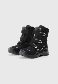 Zwarte wandelschoenen met een gestructureerde bovenkant, beveiligd met drie klittenbandstraps. Voorzien van een robuuste zool met een duidelijk profiel voor grip.