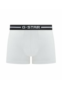 Boxers blancs G-Star avec une ceinture noire portant le logo "G-STAR" en blanc. Fabriqués en tissu doux avec une texture lisse.
