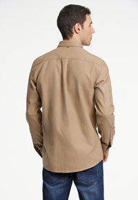 Katoenen shirt met lange mouwen in lichtbruin, met een klassieke kraag, knoopmanchetten, een rugplooi en subtiele logodetail vlakbij de nek.