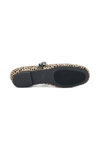 Suela de zapato con estampado de leopardo y suela de goma negra, con una superficie texturizada y detalle de hebilla plateada en la parte superior.