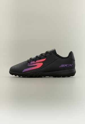 Zwarte sportschoen met gestructureerd oppervlak, rood en paars "S" logo aan de zijkant, paarse "SKX" tekst dichtbij de hiel en zwarte zool met noppen.