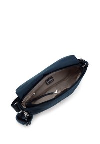 Námořnická crossbody taška se béžovým interiérem, zipovou kapsou, klipem na klíče a černým nastavitelným popruhem s chlupatým přívěskem na klíče v podobě opice.