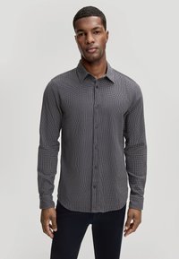 Knoopshirt in zwart-witte ruitpatroon, met een kraag, lange mouwen, knopen aan de voorkant en een normale pasvorm. Soepele stof textuur.