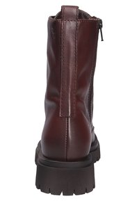 Brown leather ankle boots with a smooth finish, textured back panel, and black rubber sole featuring grooves for traction. Side zipper closure.