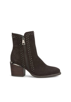 Botas de tobillo de ante marrón con acentos de tachuelas, cremallera lateral y tacón apilado. El diseño presenta una textura suave y patrones distintos.