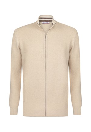 Beige gebreide cardigan met een ritsluiting aan de voorkant, hoge kraag en twee voorzakken. Heeft een geribbelde textuur en subtiele gestreepte accenten bij de kraag.