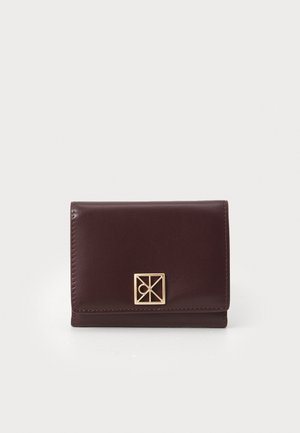Dark brown leather wallet with a gold geometric clasp, displayed closed against a white background.