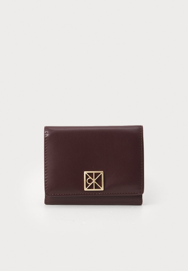 Dark brown leather wallet with a gold geometric clasp, displayed closed against a white background.