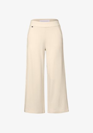Pantalon large beige avec une texture lisse, une taille élastique et des poches latérales. Fabriqué en tissu doux pour le confort et la liberté de mouvement.