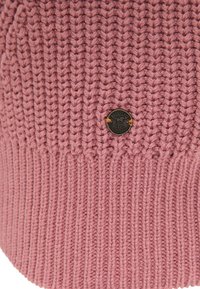 Pletená čepice v jemné růžové látce, se žebrovaným designem a malou kulatou kovovou nášivkou na přední straně.