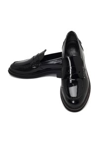 Zwarte gepatineerde leren loafers met een gladde textuur, voorzien van een decoratieve band over de wreef en een zacht afgeronde neus.