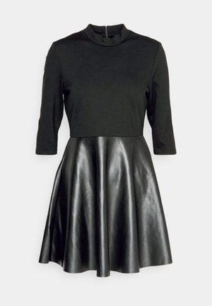 Fekete ruha, illeszkedő, hosszú ujjú felső résszel, puha anyagból, és fényes műbőrből készült bővülő szoknyával, magas nyakkal és hátsó cipzárral.