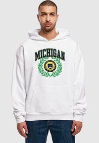 Fehér kapucnis pulóver, amelyen a "MICHIGAN" felirat sötétkék színben, felette egy zöld babérkoszorú található. A pulóver közepén a egyetemi címer kör alakú emblémája látható. Elöl zseb található.