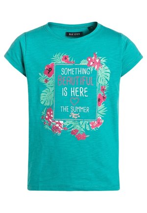 T-shirt turquoise à manches courtes avec un motif floral et le texte "Something beautiful is here, the summer" centré sur le devant.