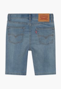 Vaaleansiniset farkkutekniset Levi's-shortsit, joissa on takataskut, ompeludetaljit, vyölenkit ja ruskea merkkilogo vyötäröllä.