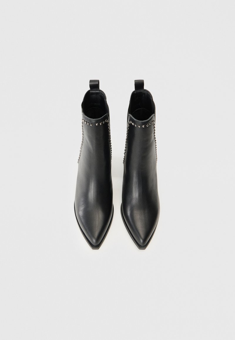 Schwarze Leder-Ankle-Boots mit spitz zulaufenden Zehen und Reißverschluss. Dekorative Nieten zieren die Seiten, mit einer glatten Oberfläche und schlankem Design.