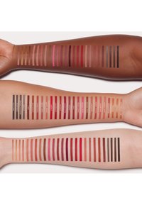 Drei Arme mit Farbmuster von Lippenstiftnuancen: vielfältige Farben von tiefen Rottönen bis hin zu Nude-Tönen, in ordentlichen horizontalen Reihen mit Beschriftungen präsentiert.