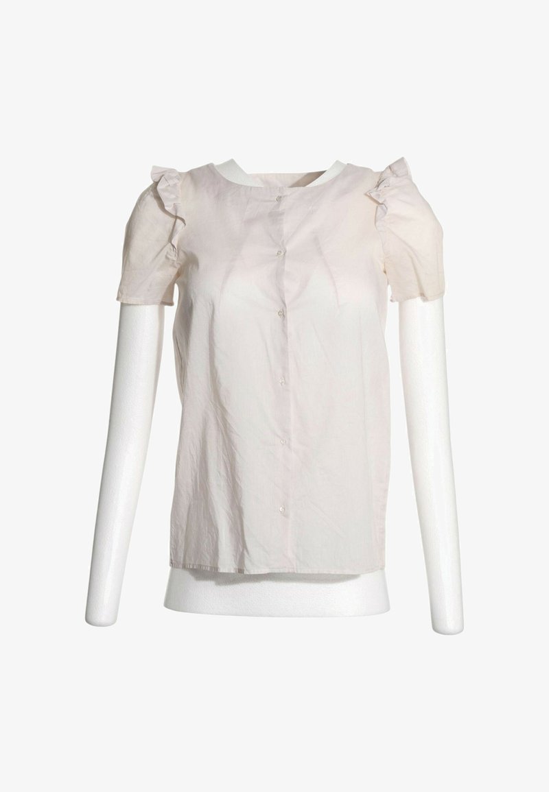 Chemisier rose clair à manches courtes avec volants aux épaules et boutons à l'avant, présenté sur un buste de mannequin blanc.