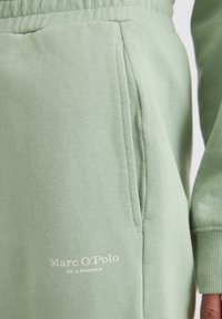 Lichtgroene hoodie van zacht stof, met een voorvak, ribgebreide manchetten en geborduurd merklogo. Glad textuur met een relaxte pasvorm.