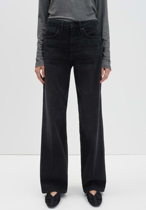Zwarte wijde spijkerbroek met een hoge taille, vijf zakken en riemlussen, gemaakt van denim. Gepaard met een grijze langslibtop.