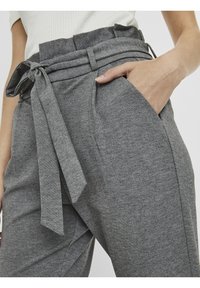 Gray jogger pants made of soft fabric feature a high waistband with a knot tie detail, side pockets, and a relaxed fit for comfort.