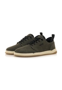 Zapatos de ante verde oscuro con acentos negros, diseño con cordones y suela de goma beige. Presentan una puntera redondeada y un branding minimalista.