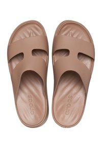 Braune Crocs-Slide-Sandalen mit zwei ausgeschnittenen Riemen, einem geformten Fußbett, einer glatten Gummistruktur und einem eingeprägten Logo auf dem Fußbett.