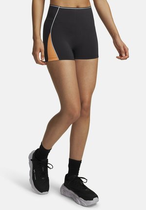 Zwart sportshort met hoge taille en oranje zijpanelen met witte accenten. Gemaakt van glad, rekbaar materiaal voor comfort en flexibiliteit.