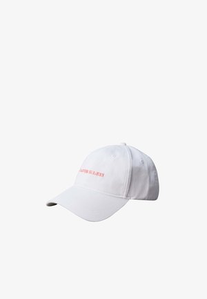 Weißes Calvin Klein Baseballcap mit gebogenem Schirm und gesticktem rotem Logo vorne vor einfarbig weißem Hintergrund.